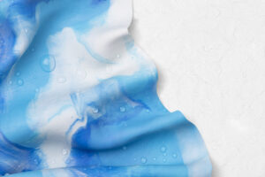 “Blue and white patterned fabric with water droplets, creating a fluid, textured appearance.